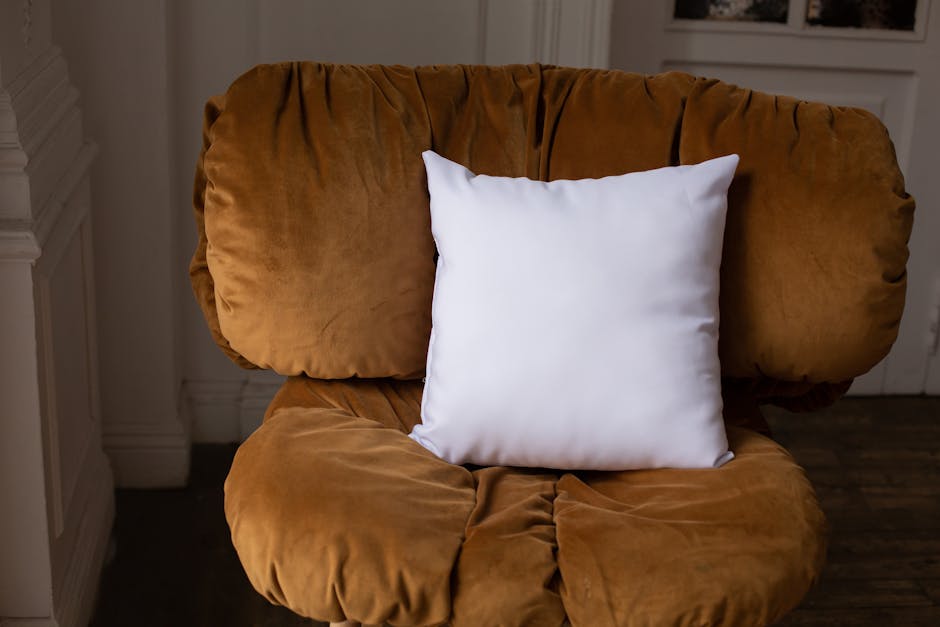 A cozy velvet chair with a white pillow providing comfort in an indoor setting.